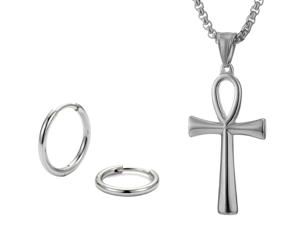 Small hoop earrings beside a polished ankh pendant, in stainless steel